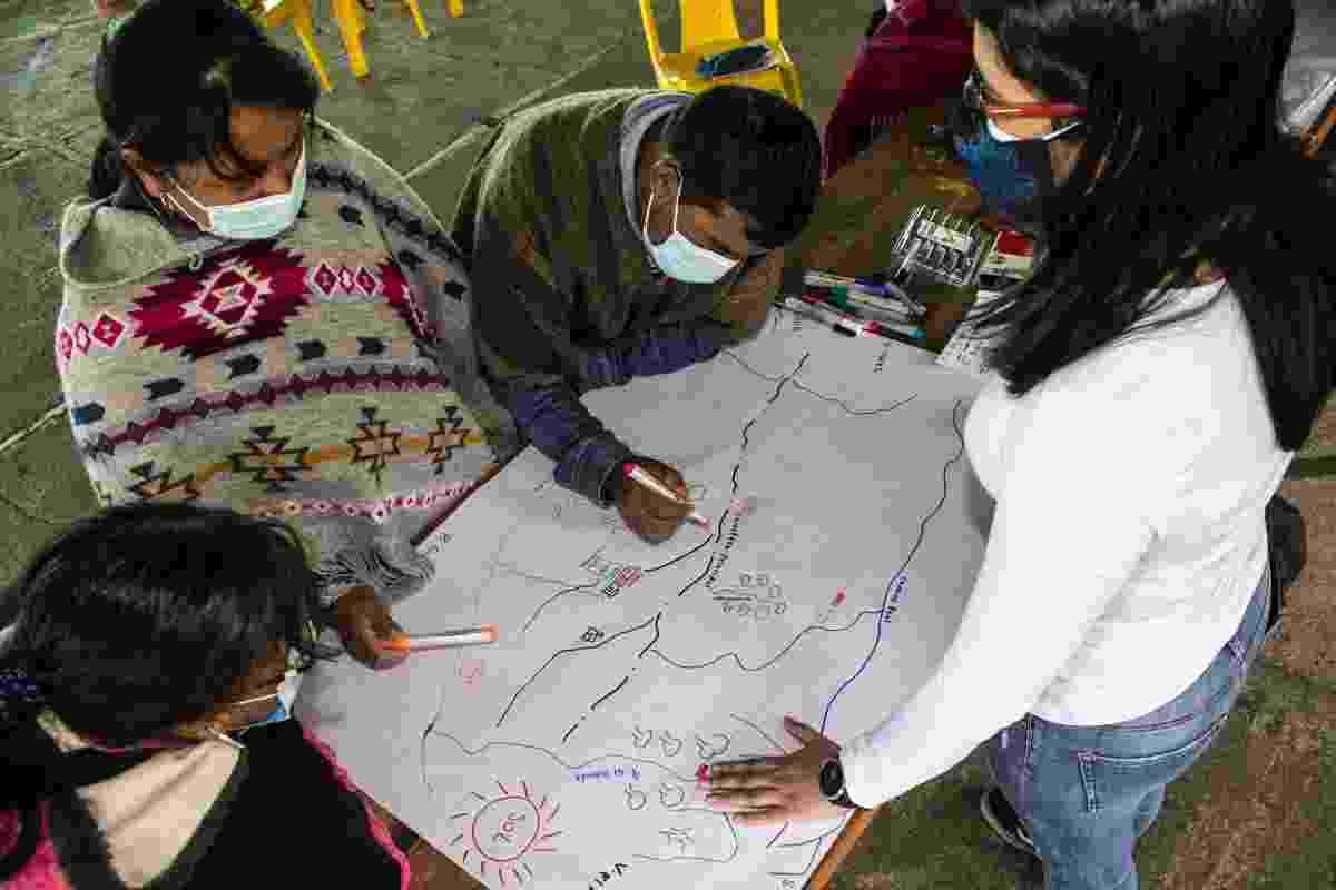 A view from above of people of the Kisgó reservation and Hub colleagues working together to co-create maps of their territory